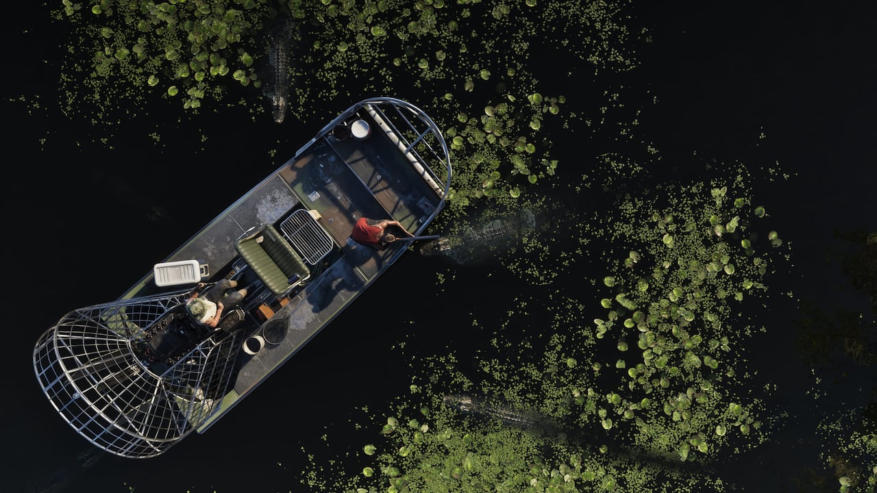 Airboat moves through a narrow waterway surrounded by dense Grassrivers vegetation